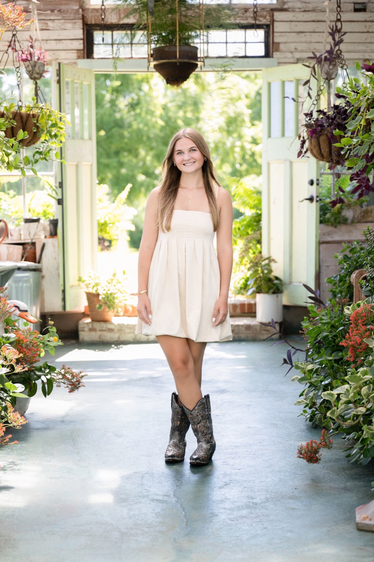 Senior portrait in a bright greenhouse