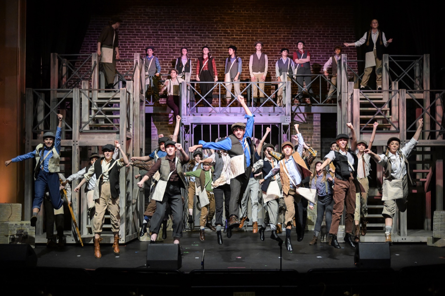 Theater ensemble jumping together on stage